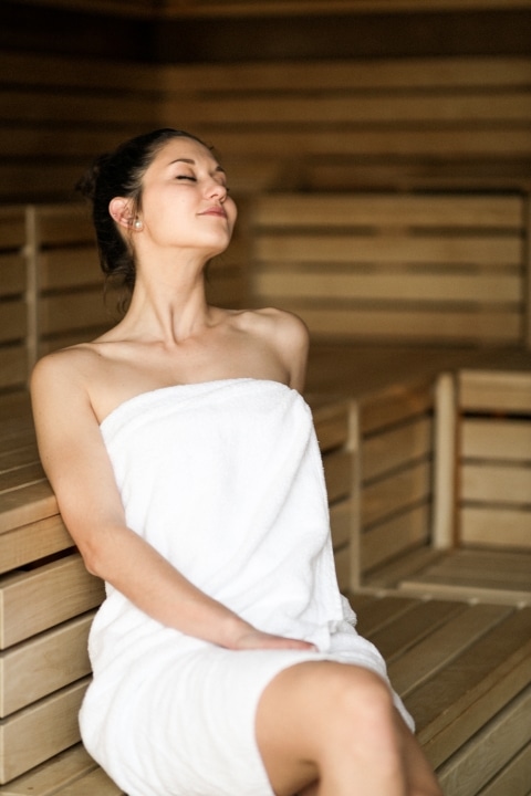 Eine junge Dame entspannt in der Sauna.