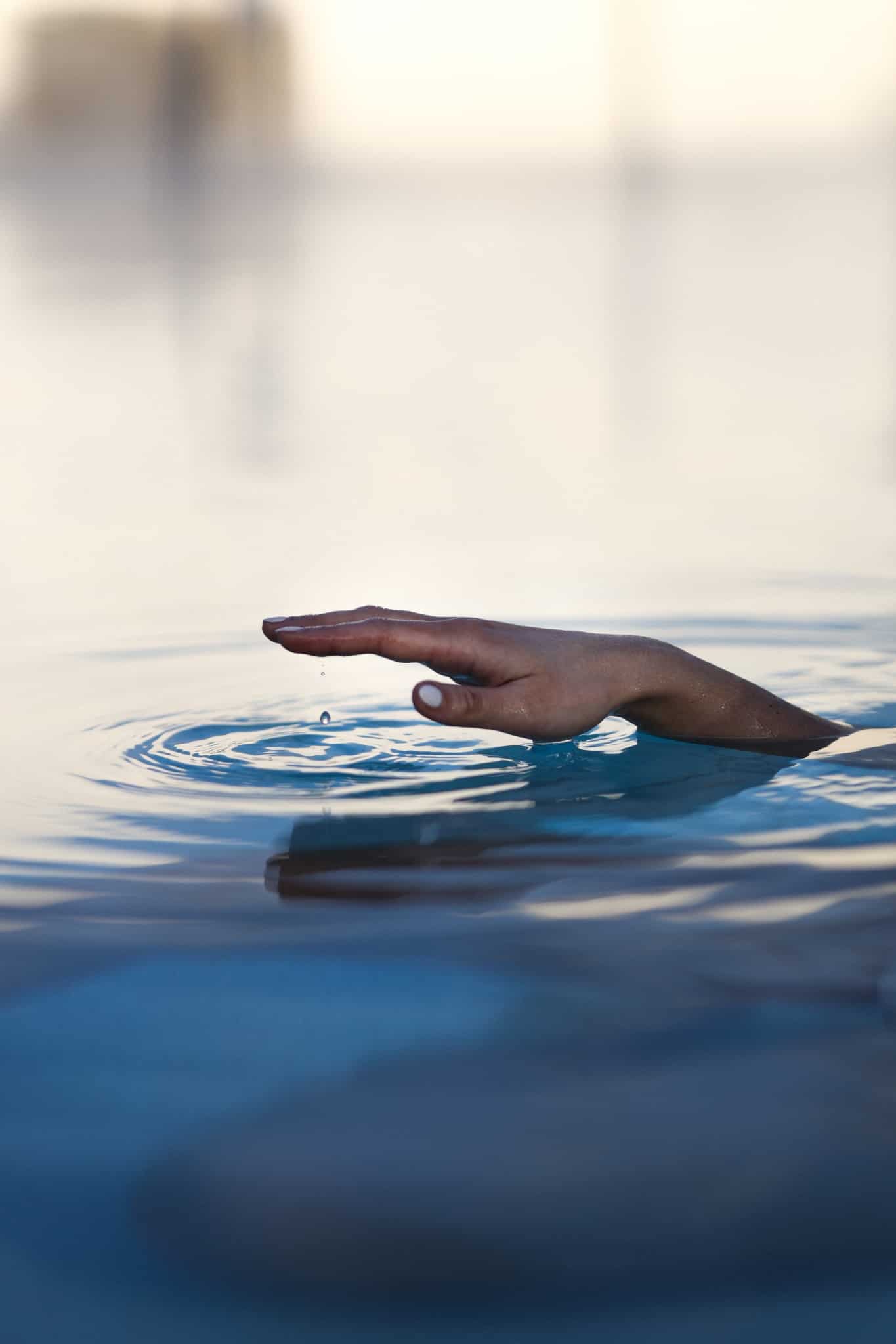 Eine ausgestreckte Hand ragt aus dem Wasser heraus.