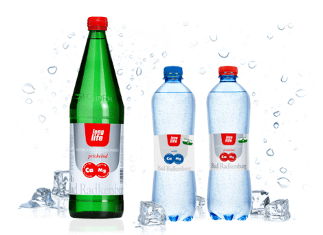 Eine Glas- und zwei Plastikflaschen mit Long Life Mineralwasser.